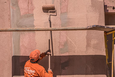 Tesuque Stucco contractor applying prime to exterior stucco wall